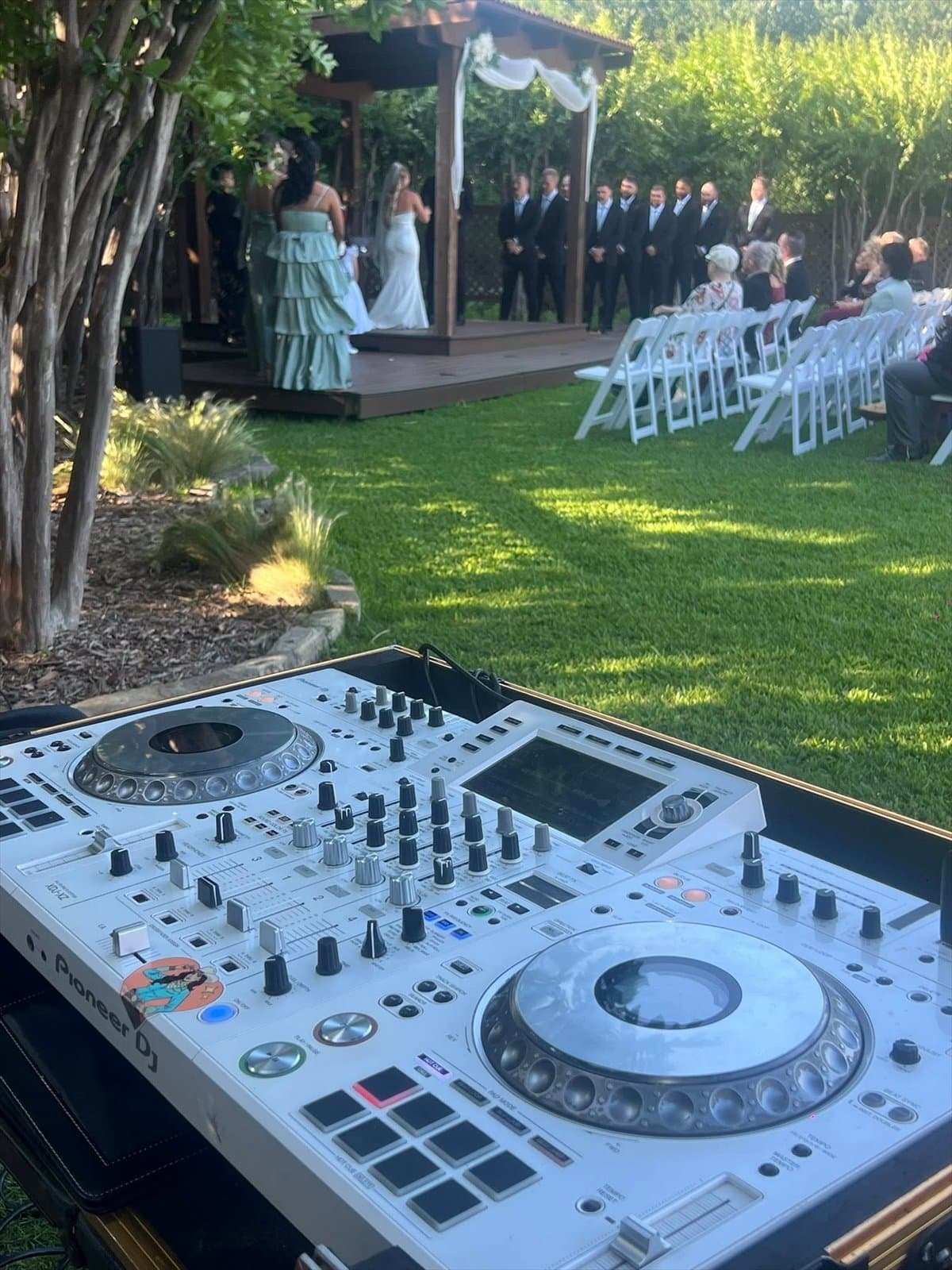 White Pioneer DJ controller on the lawn at an outdoor wedding ceremony