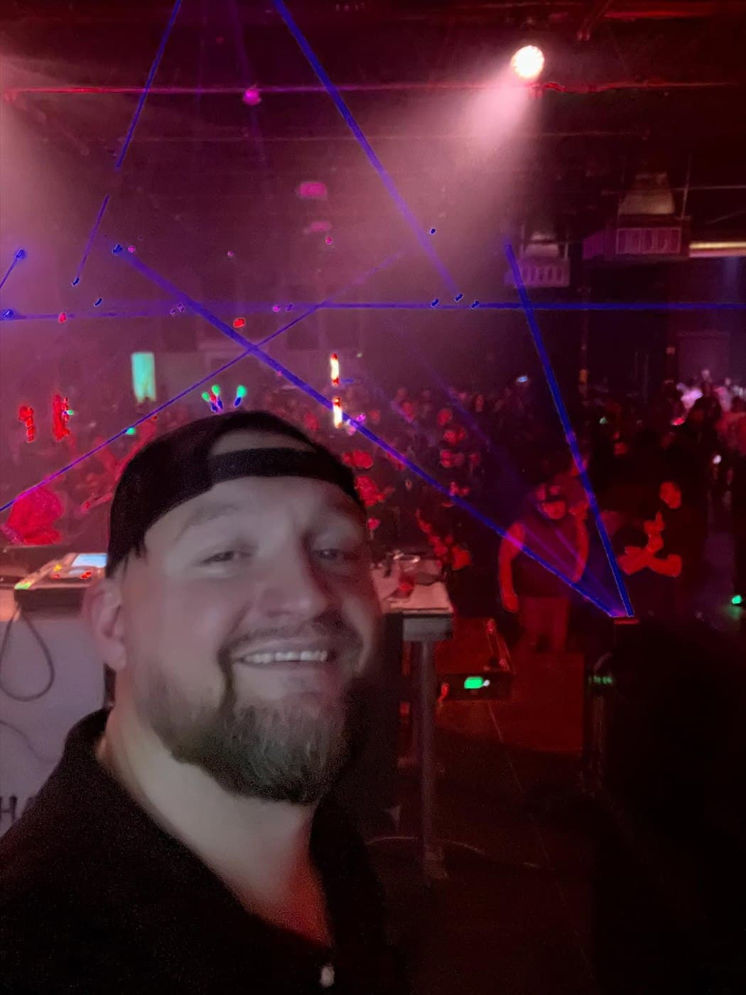 John Wayne smiling for a selfie at a club